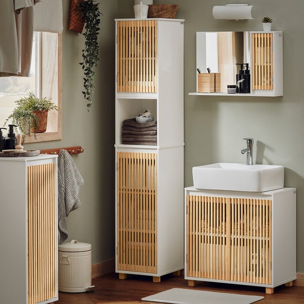 Badezimmer mit Waschbecken, Spiegel und mehreren Aufbewahrungsschränken aus Holz