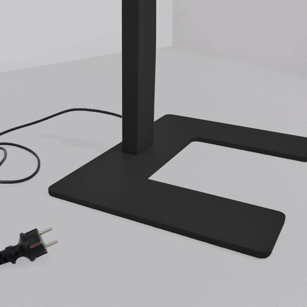 Schwarzer Lampenfuß in U-Form mit Netzkabel und Stecker.