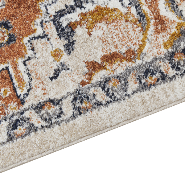 Nahaufnahme eines Teppichs mit orientalischem Muster in Beige, Orange und Blau, weiche Textur mit geketteltem Rand.