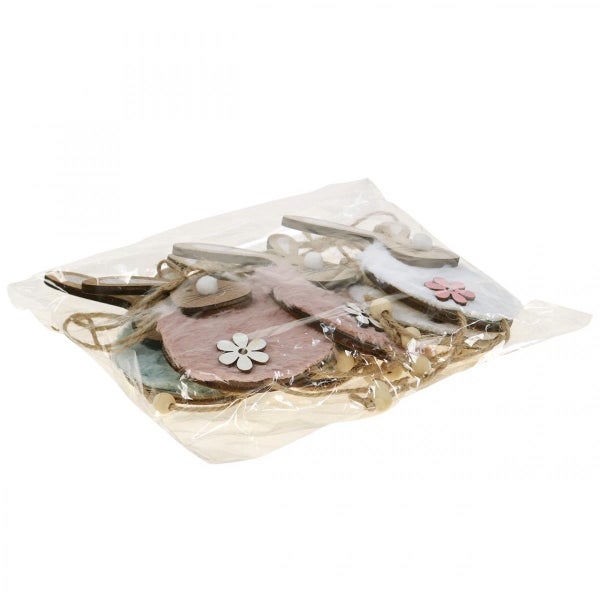 Verpackung mit hölzernen Osteranhängern in Hasenform mit Blumenornamenten.