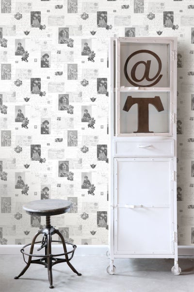 Raumansicht mit Tapete mit Briefmotiv, Stuhl und weißem Schrank