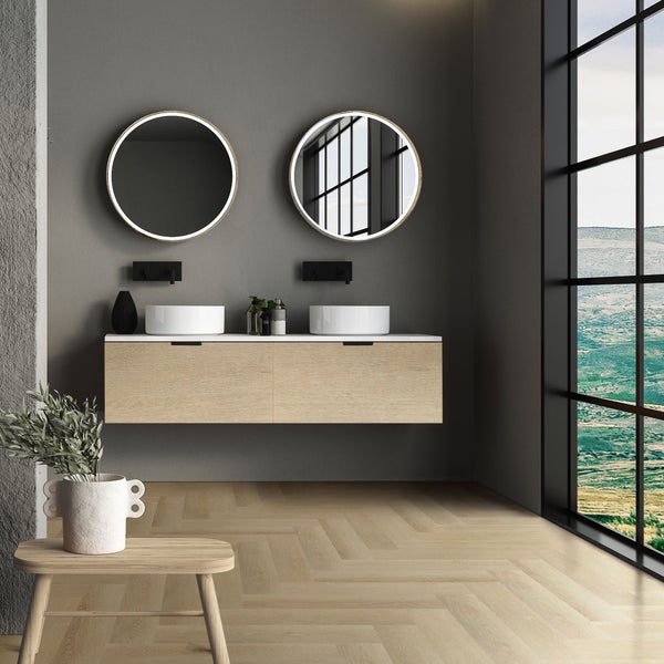 Modernes Badezimmer mit Doppelwaschtisch aus Holz, zwei Aufsatzwaschbecken, runden LED Spiegeln und Fischgrätparkett vor großem Fenster.