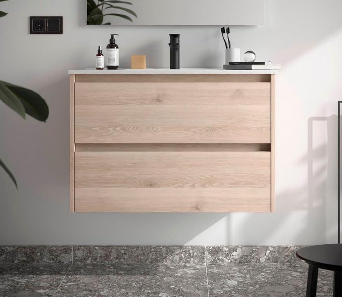 Moderner wandhängender Waschbeckenunterschrank in heller Holzoptik mit zwei Schubladen, weißem Waschtisch und schwarzer Armatur.