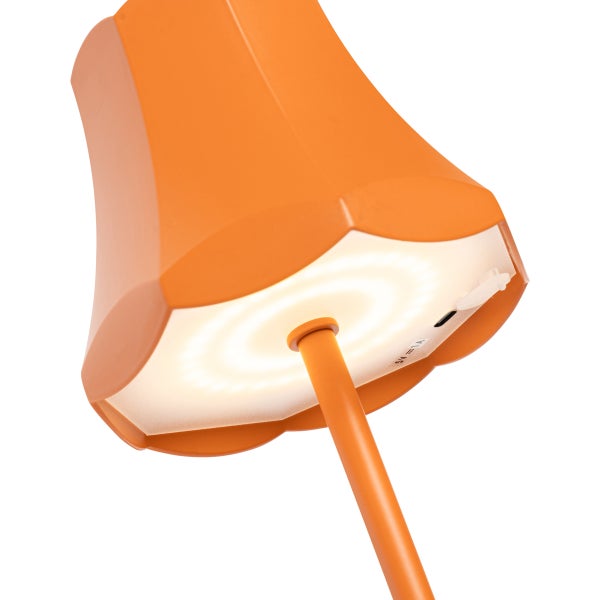 Detailansicht einer orangefarbenen Tischleuchte mit einem Ladeanschluss an der Unterseite des Lampenschirms.