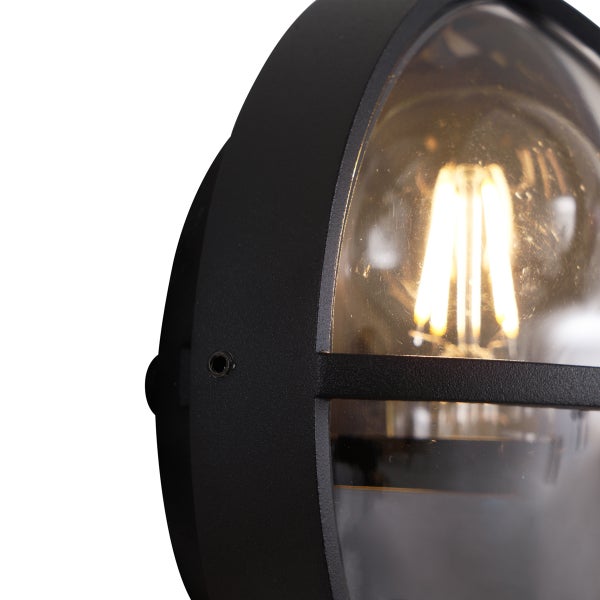 Nahaufnahme einer ovalen Außenwandleuchte mit schwarzem Rahmen, klarem Glas und sichtbarem LED-Leuchtmittel.