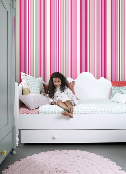 Mädchenzimmer mit gestreifter Tapete, Bett und rundem Teppich