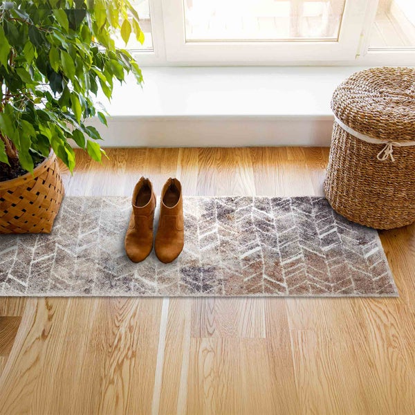 Szene mit Teppich, Stiefeln, Pflanze und Wäschekorb in einem hellen Raum.