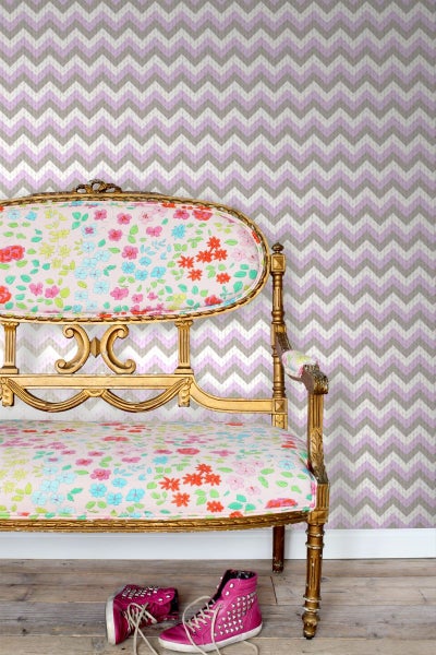 Dekoratives Zimmer mit gemusterter Tapete und antikem Sofa