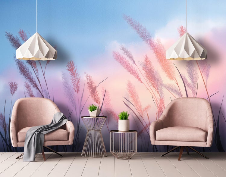 Wohnzimmer mit zwei Sesseln, Beistelltischen, Pendelleuchten und einer Tapete mit Gras-Motiv.