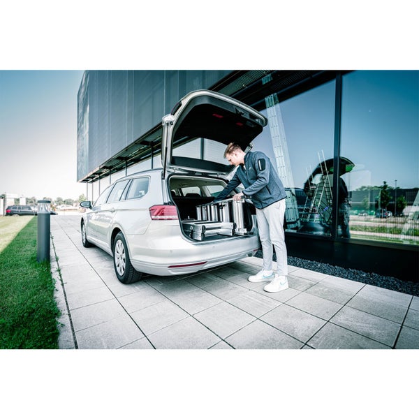 Eine Person verstaut eine Mehrzweckleiter in einem Kombi.
