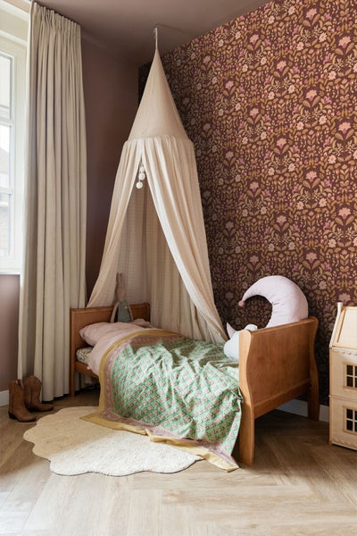 Kinderzimmer mit Himmelbett, gemusterter Tapete und Holzfußboden