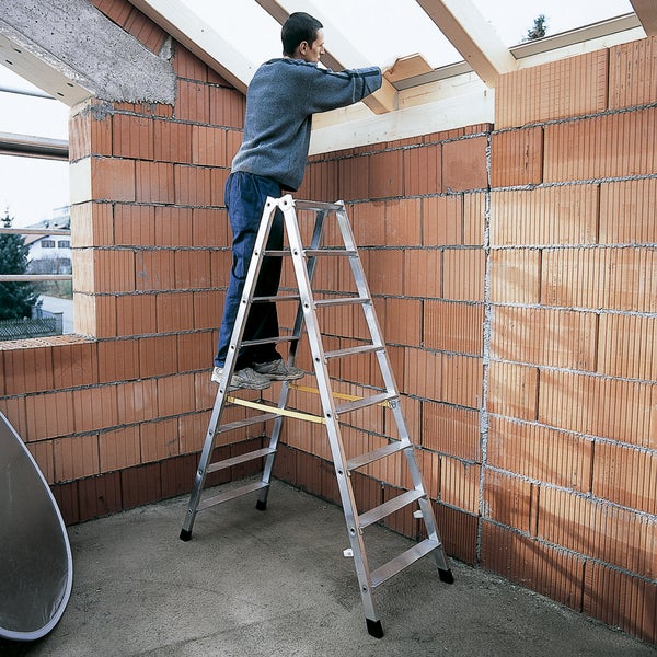 Mann auf einer Stufenleiter bei Bauarbeiten im Innenbereich.