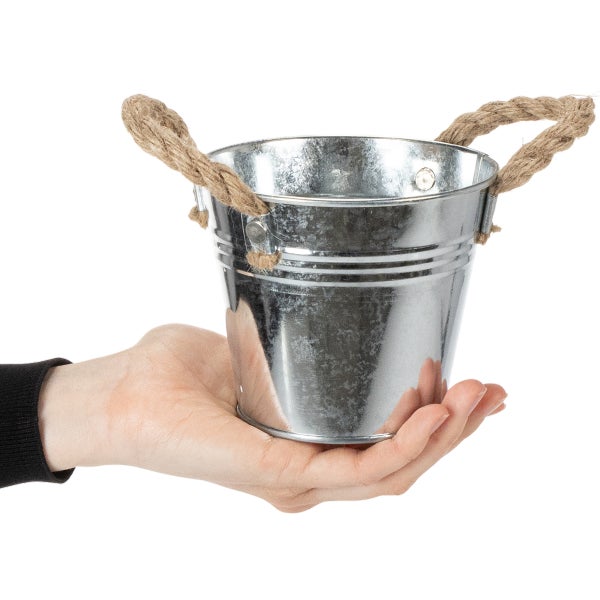 Kleiner Zinkeimer mit Kordelgriffen in einer Hand gehalten.