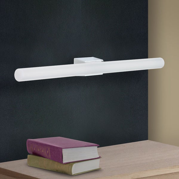 Moderne LED Leuchte in Röhrenform als Wandleuchte montiert, platziert über zwei aufeinander liegenden Büchern auf einem Holzregal.