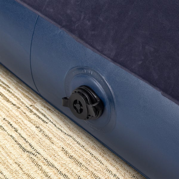 Detailansicht eines blauen Luftbetts mit einem schwarzen Luftventil aus Kunststoff.