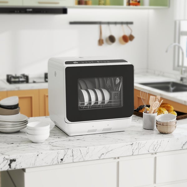 Kompakter Tischgeschirrspüler auf einer Küchenarbeitsplatte aus Marmor mit Sichtfenster und Geschirr im Innenraum.