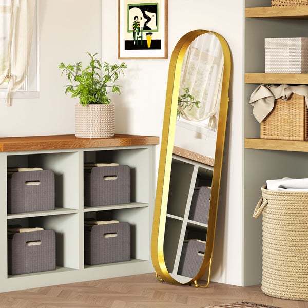 Szene mit Stehspiegel mit goldenem Rahmen, Regalen und Dekoration