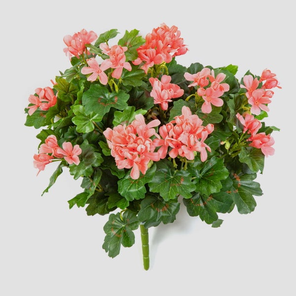 Künstliche Geranie mit lachsfarbenen Blüten und grünen Blättern.