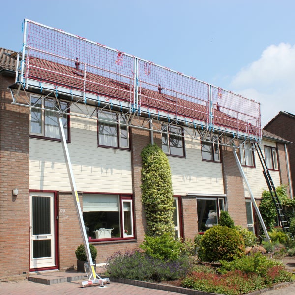 Modulares Arbeitsplattform-System aus Aluminium mit rotem Sicherheitsnetz an einer Hausfassade für Dacharbeiten.