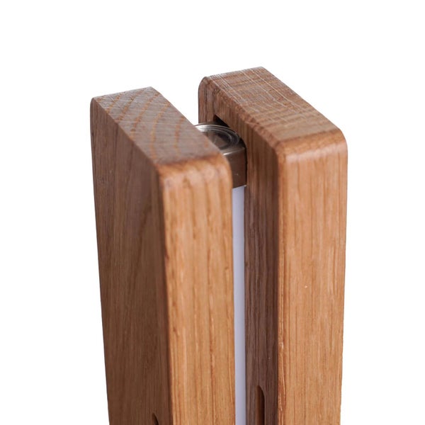 Detailansicht einer modernen Tischleuchte aus Holz mit einem schmalen Lichtelement zwischen zwei Holzelementen.
