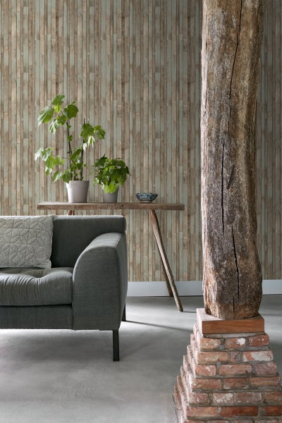 Wohnzimmer mit grauer Couch, Holztisch und Wandtapete in Holzoptik