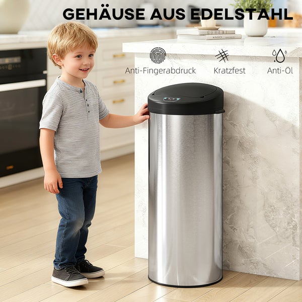 Kind steht in der Küche neben einem runden Abfalleimer aus Edelstahl mit Sensor-Deckel, der resistent gegen Fingerabdrücke, Kratzer und Öl ist.