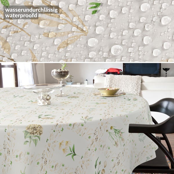 Wasserfeste Tischdecke mit floralem Muster auf einem runden Tisch, Detailaufnahme zeigt abperlende Wassertropfen auf der Oberfläche.