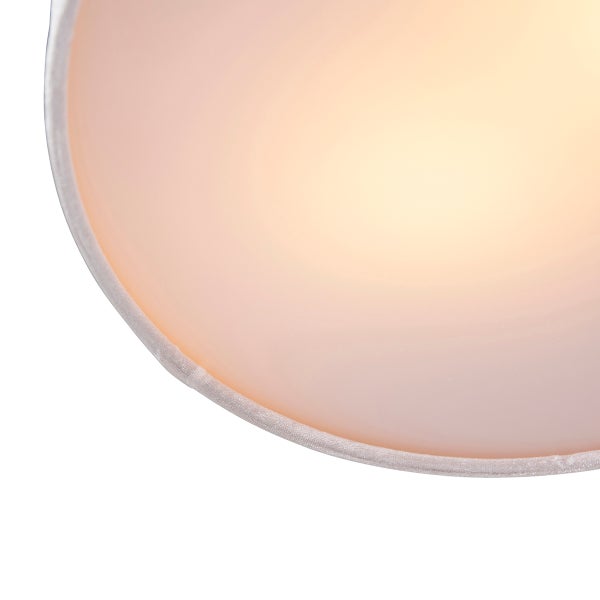 Nahaufnahme eines runden Lampenschirms aus Stoff mit warmem Licht.