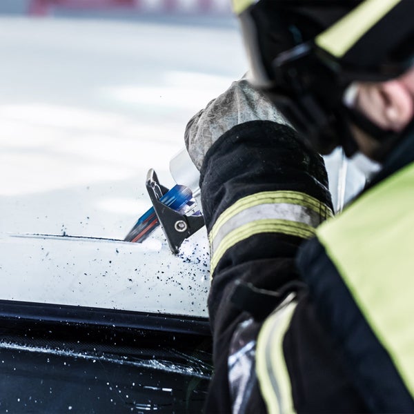 Feuerwehrmann schneidet mit einem Glasschneider eine Autoscheibe