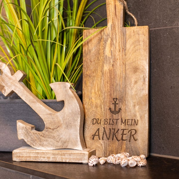 Dekoration mit Holztisch, Anker, Muscheln und Zimmerpflanze