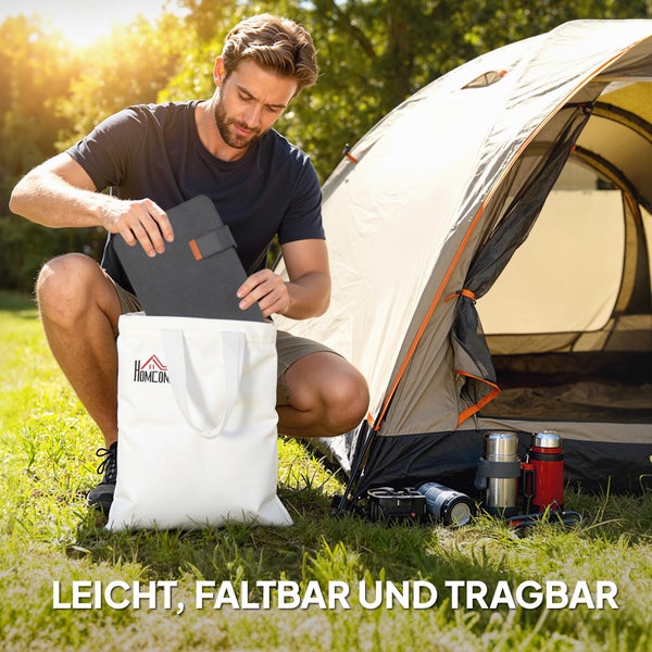 Ein Mann verstaut ein leichtes, faltbares Solarpaneel in einer Tasche mit Homcom Logo neben einem Campingzelt.