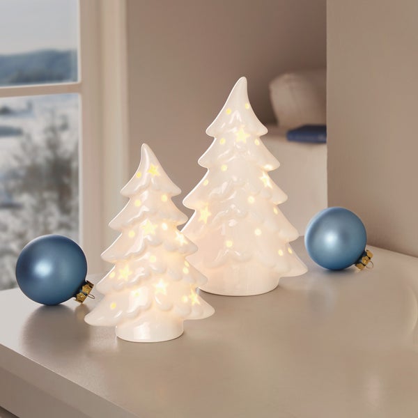 Zwei beleuchtete, weiße Weihnachtsbäume aus Keramik mit Weihnachtskugeln