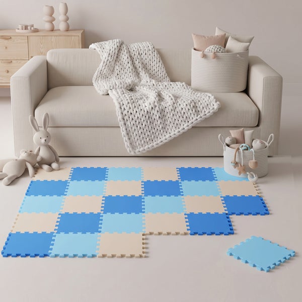 Spielteppich aus ineinandergreifenden Schaumstoffmatten mit Schachbrettmuster in Blau und Beige für Kinderzimmer vor einem Sofa.