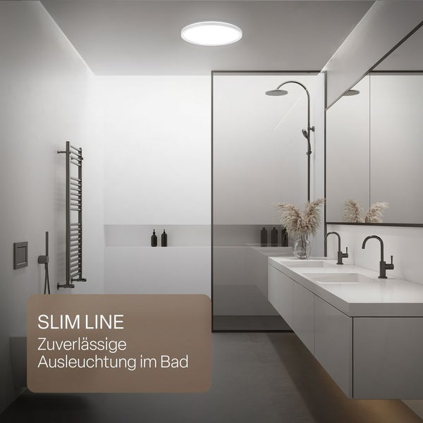 Modernes Badezimmer mit einer runden LED-Deckenleuchte, Doppelwaschtisch, Glasdusche und schwarzen Armaturen.