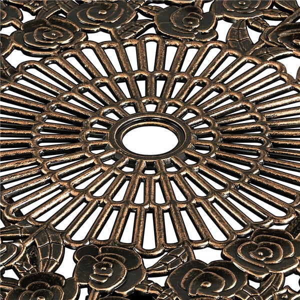 Detailansicht einer runden Tischplatte aus Aluminiumguss mit floralem Muster und Sonnenschirmloch.