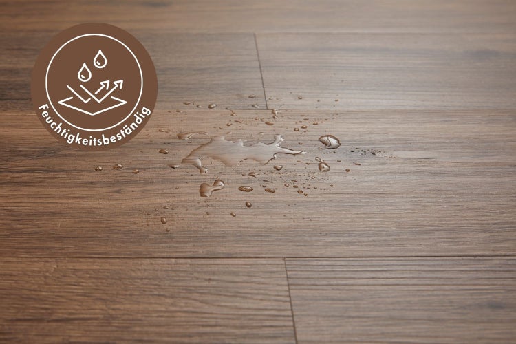 Feuchtigkeitsbeständiger Laminatboden in Holzoptik mit einer Wasserpfütze auf der Oberfläche