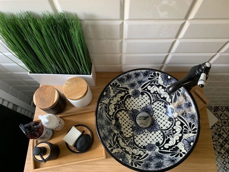 Badezimmer Waschbecken mit floralem Muster, Armatur und Badzubehör auf einem Holztablett