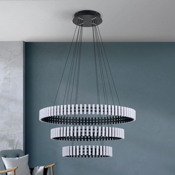 Moderne dreistufige Pendelleuchte als Ringdesign mit Lichtelementen in einem Wohnraum
