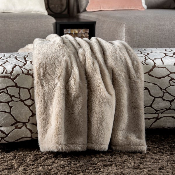 Beige Kuscheldecke auf einem Sofa