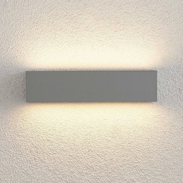 Rechteckige Wandleuchte aus Metall mit Lichtaustritt nach oben und unten an einer strukturierten Wand.
