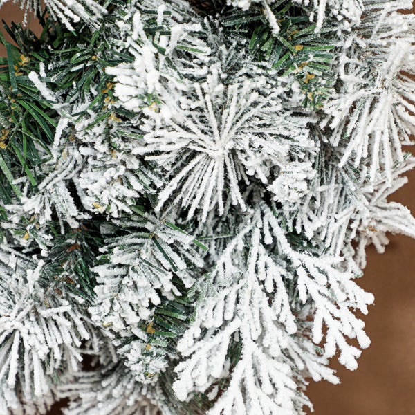 Detailaufnahme eines künstlichen Weihnachtsbaums mit beschneiten Nadeln.