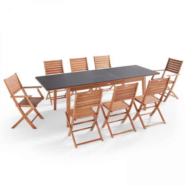 Gartensitzgruppe bestehend aus einem rechteckigen Tisch mit dunkler Platte und acht klappbaren Gartenstühlen aus Holz.