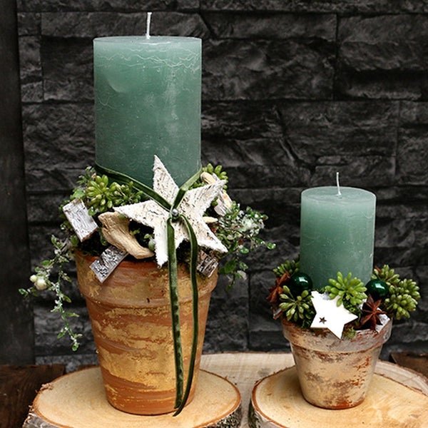 Dekorative Kerzen in Tontöpfen mit Sternverzierungen