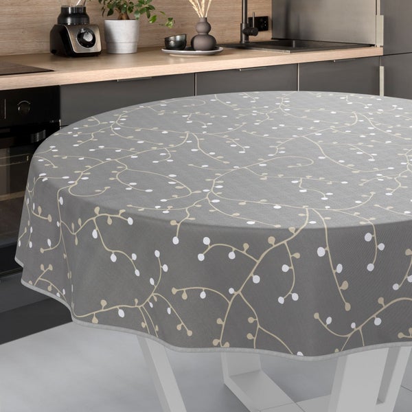 Runder Tisch mit grauer Tischdecke und floralem Muster in einer Küchenumgebung.