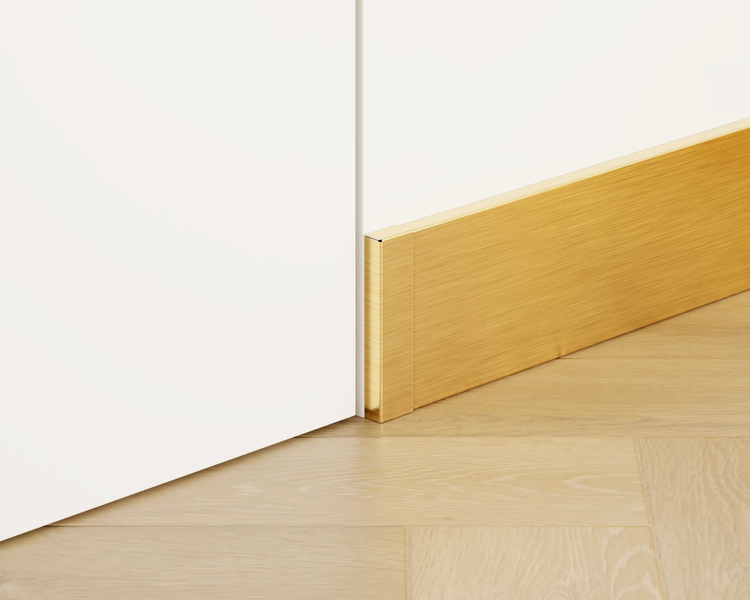 Sockelleiste aus Metall neben einer Wand auf einem Holzboden