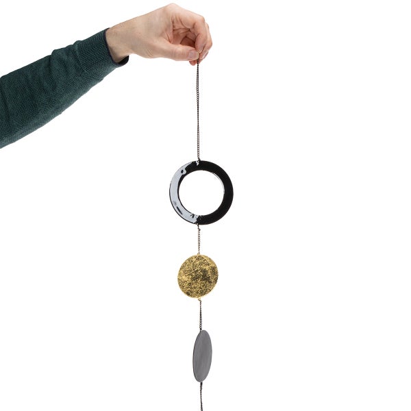 Hand hält Mobile mit Kreis und Ellipsen