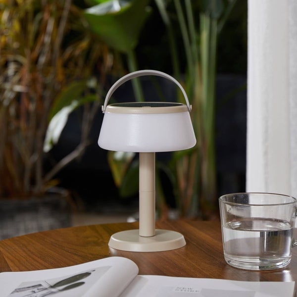 Tragbare LED Solar-Tischleuchte mit Tragegriff auf einem Holztisch im Außenbereich