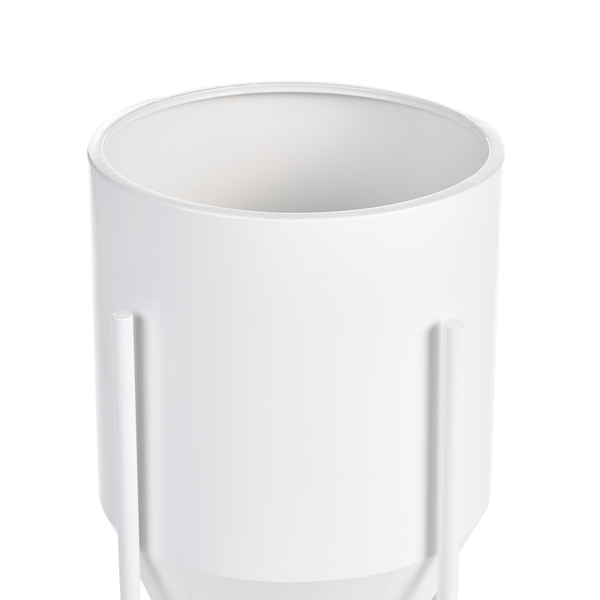 Weißer zylindrischer Übertopf aus Metall auf einem schlichten Metallständer.