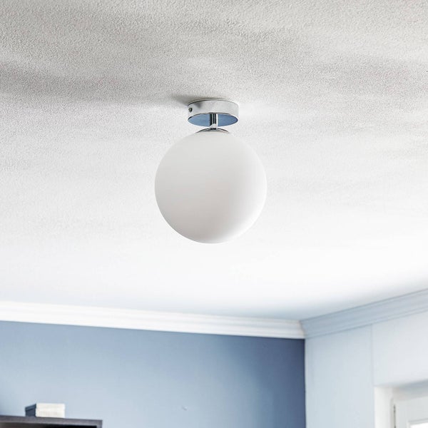 Kugelförmige Deckenlampe aus weißem Glas mit verchromter Halterung, montiert an einer Zimmerdecke.
