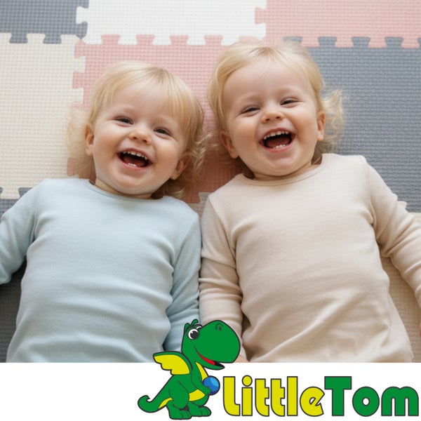 Zwei lachende Kleinkinder auf einer Schaumstoff-Puzzlematte in einem hellen Raum, LittleTom Logo.